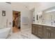 Bright bathroom featuring double sink vanity, luxurious soaking tub, and walk-in closet at 4068 N 155Th Ln, Goodyear, AZ 85395