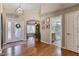 Welcoming entryway with hardwood floors and beautiful lighting fixture with a front door view at 4068 N 155Th Ln, Goodyear, AZ 85395