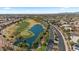 Aerial view of golf course community featuring mature palm trees lining an idyllic lake and surrounding green fairways at 4068 N 155Th Ln, Goodyear, AZ 85395