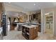 Open kitchen featuring a central island, wood cabinets, and a view of the living area at 4068 N 155Th Ln, Goodyear, AZ 85395