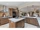 Bright kitchen with stainless steel appliances, an island with a white countertop and wood cabinets at 4068 N 155Th Ln, Goodyear, AZ 85395