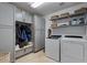 Laundry room featuring grey cabinets, storage shelves, bench and modern washer/dryer at 4068 N 155Th Ln, Goodyear, AZ 85395