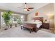 Tranquil main bedroom featuring a ceiling fan, a bright window and a comfortable seating area at 4068 N 155Th Ln, Goodyear, AZ 85395