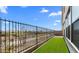 A backyard features a black metal fence, artificial turf, and a view of the neighborhood beyond the property line at 4395 N 203Rd Ave, Buckeye, AZ 85396