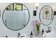 Well-lit bathroom featuring dual sinks, round mirrors, and modern black fixtures at 4395 N 203Rd Ave, Buckeye, AZ 85396