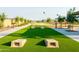 Landscaped community space with cornhole game, benches, and lush turf for outdoor enjoyment at 4948 W Walatowa St, Laveen, AZ 85339