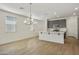 Open-concept kitchen and dining area with a stylish chandelier and wood-look tile flooring at 4948 W Walatowa St, Laveen, AZ 85339