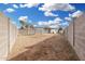 Expansive dirt backyard enclosed by a tall cinder block fence under a bright blue sky at 525 S 99Th St, Mesa, AZ 85208