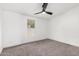 Cozy bedroom featuring neutral carpet, ceiling fan, and natural light from the window at 525 S 99Th St, Mesa, AZ 85208