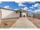 Exterior view of the home featuring a covered patio, concrete driveway, and dirt landscaping at 525 S 99Th St, Mesa, AZ 85208