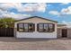 The house has many windows with black shutters, gravel landscaping, and privacy fencing at 525 S 99Th St, Mesa, AZ 85208