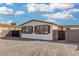 The house has many windows with black shutters, gravel landscaping, and privacy fencing at 525 S 99Th St, Mesa, AZ 85208