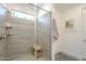 Bathroom with a glass enclosed shower featuring gray tiles, a rainfall shower head, and a built-in shelf at 5360 S 98Th Pl, Mesa, AZ 85212