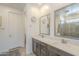 Bathroom featuring a dual sink vanity with marble countertops, mirrors, and gray-tiled shower at 5360 S 98Th Pl, Mesa, AZ 85212