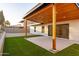 Outdoor patio featuring a covered area, artificial grass, and a sliding glass door at 5449 E Cambridge Ave, Phoenix, AZ 85008