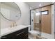 Modern bathroom featuring a glass-enclosed shower, round mirror, and vanity at 5449 E Cambridge Ave, Phoenix, AZ 85008