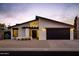 Charming single-story home features a modern design with a black garage door and desert landscaping at 5449 E Cambridge Ave, Phoenix, AZ 85008