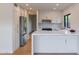 Well-lit kitchen with stainless steel refrigerator, white cabinetry, marble countertops, and modern appliances at 5449 E Cambridge Ave, Phoenix, AZ 85008