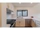 Modern kitchen with black stovetop, stainless steel dishwasher and sink, white cabinetry, and marble countertops at 5449 E Cambridge Ave, Phoenix, AZ 85008