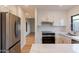 Kitchen with stainless steel fridge, marble countertops and backsplash, and white cabinets with gold hardware at 5449 E Cambridge Ave, Phoenix, AZ 85008