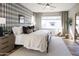 Well-lit bedroom showcases neutral tones, plaid accent wall, a cozy chair, and ample natural light for a tranquil setting at 624 N Vine St, Chandler, AZ 85225