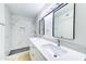 Modern bathroom featuring marble-look tiling, double sink vanity, framed mirrors, and walk-in shower at 6333 N 49Th Ave, Glendale, AZ 85301