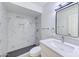 Modern bathroom featuring marble-look tiling, a sleek vanity, framed mirror, and walk-in shower at 6333 N 49Th Ave, Glendale, AZ 85301