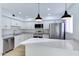 Modern kitchen with stainless steel appliances, white cabinets, quartz countertops, and pendant lighting over the island at 6333 N 49Th Ave, Glendale, AZ 85301