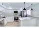 Contemporary kitchen featuring stainless steel appliances, white cabinetry, quartz countertops, and stylish pendant lighting at 6333 N 49Th Ave, Glendale, AZ 85301