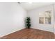 Clean bedroom with light hardwood floors, modern ceiling fan, and plantation shutters at 7118 E Juanita Ave, Mesa, AZ 85209