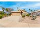 Attractive single-level home with a tile roof, desert landscaping, and a spacious driveway leading to a garage at 7118 E Juanita Ave, Mesa, AZ 85209