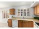 Functional kitchen with wooden cabinets, stainless steel sink and tile backsplash at 7118 E Juanita Ave, Mesa, AZ 85209