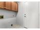 Neutral laundry room with overhead storage cabinets and a white utility door at 7118 E Juanita Ave, Mesa, AZ 85209