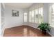 Bright living area featuring hardwood floors, fresh paint, built-in shelves, and a large window with plantation shutters at 7118 E Juanita Ave, Mesa, AZ 85209