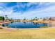 Tranquil pond surrounded by green grass and palm trees, reflecting the sky, offering a peaceful community setting at 7118 E Juanita Ave, Mesa, AZ 85209