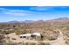 Expansive aerial view of desert home with mountain backdrop, surrounded by mature saguaro cacti and desert vegetation at 8115 E Paint Pony Dr, Carefree, AZ 85377