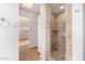 Bathroom featuring a walk-in shower, glass doors, and travertine-like tiles at 8115 E Paint Pony Dr, Carefree, AZ 85377