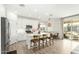 Open-concept kitchen with white cabinets, a center island, a breakfast bar, and wood-look flooring at 815 E Tucci St, San Tan Valley, AZ 85140