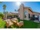 Serene backyard showcasing a seating area, green lawn, and a home with a classic tiled roof at 8812 E Riviera Dr, Scottsdale, AZ 85260