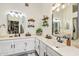 Bathroom features double sinks, white cabinets, a large mirror, and modern lighting fixtures at 8812 E Riviera Dr, Scottsdale, AZ 85260