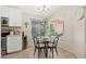 Cozy dining area with a round glass table, seating for four, and natural light from the large window at 8812 E Riviera Dr, Scottsdale, AZ 85260