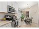 Eat-in kitchen features a round dining table with seating for four and updated stainless steel appliances at 8812 E Riviera Dr, Scottsdale, AZ 85260