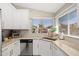 Bright kitchen featuring white cabinets, stainless steel appliances, and a window with a neighborhood view at 8812 E Riviera Dr, Scottsdale, AZ 85260