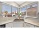 Kitchen sink area with white cabinets, neutral countertops, stainless steel sink, and a view outside at 8812 E Riviera Dr, Scottsdale, AZ 85260