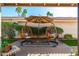 Inviting outdoor patio with hanging chairs, shade umbrella, and lush landscaping, perfect for relaxation at 8812 E Riviera Dr, Scottsdale, AZ 85260