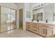 Bright bathroom with double vanity, modern lighting, and a sliding glass shower door at 9039 W Wescott Dr, Peoria, AZ 85382