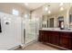 A well-lit bathroom featuring a walk-in shower, vanity with dark wood cabinets at 9450 W Georgia Ave, Glendale, AZ 85305