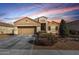 Inviting single-story home showcasing a two-car garage, desert landscaping, and picturesque sunset at 9450 W Georgia Ave, Glendale, AZ 85305