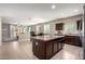 Open-concept kitchen featuring dark cabinets, granite countertops, and a spacious central island with dining at 9450 W Georgia Ave, Glendale, AZ 85305