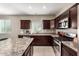 Well-equipped kitchen showcasing dark cabinetry, stainless steel appliances, and a central island with granite countertop at 9450 W Georgia Ave, Glendale, AZ 85305